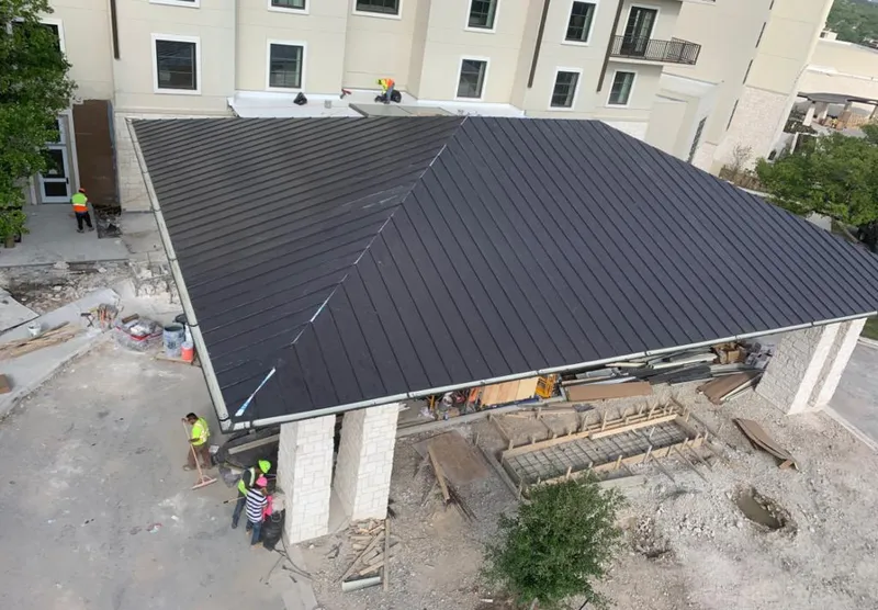 Metal roofing installation team working on a commercial building in Mont Belvieu
